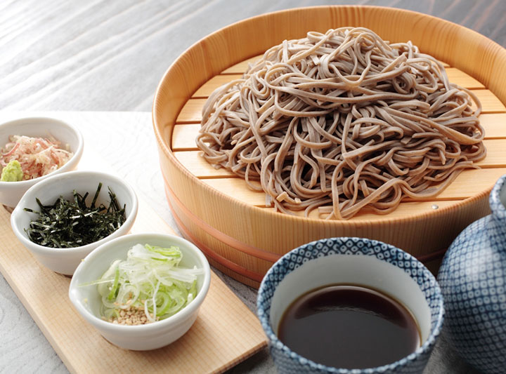 A set of Zaru soba, included Dried soba noodles, mentsuyu (noodle soup base or mixture of dashi, mirin, soy sauce), shredded nori, green onions, and wasabi.